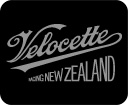 Velocette Racing New Zealand organisation logo. Classic racing motorcycle enthusiasts organisation brand. ‘Coca-Cola’ style sloped and looped copperplate lettering in metallic gold on a black background, consistent with the historic livery of Velocette motorcycles. Brands for New Zealand / International organisations.
