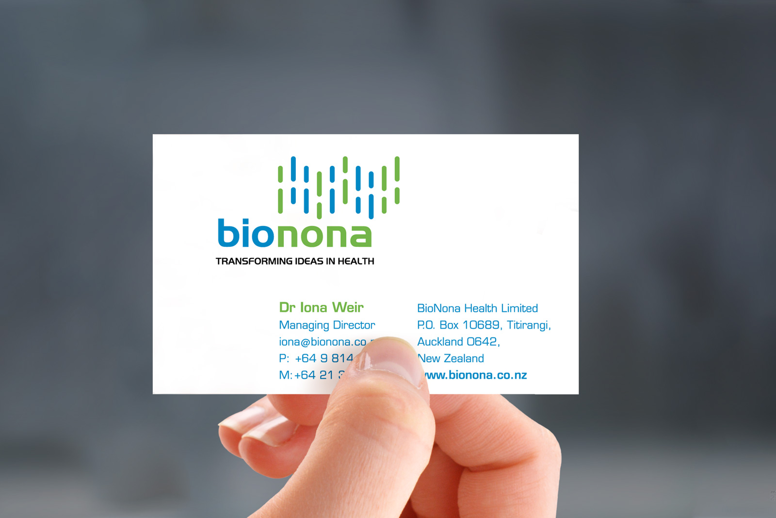Hand-held photorealistic mockup of front of Bionona business card, printed in 4 colours, litho offset.