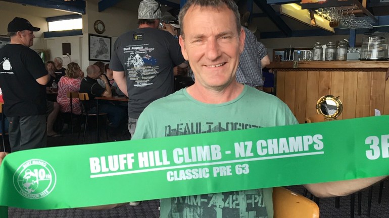 VRNZ Team leader Phil Price with Graham Peter’s Bluff HIll Climb Pre ‘63 Class sash at the Anchorage Pub, venue for the debrief after the event on Thursday evening.