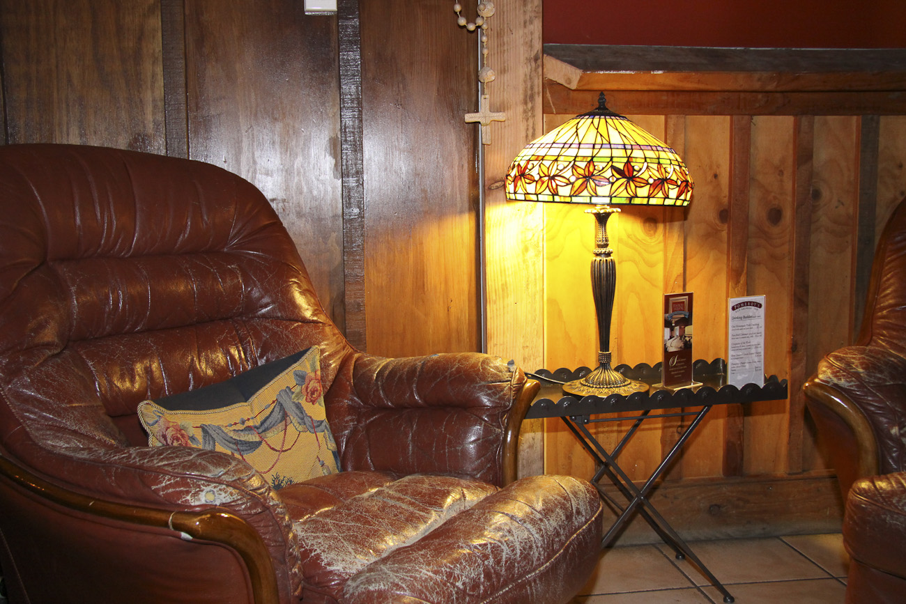 Pomeroy’s Old Brewery Inn English style pub interior details. Art Deco lamp, wood panelling and comfy leather armchair.