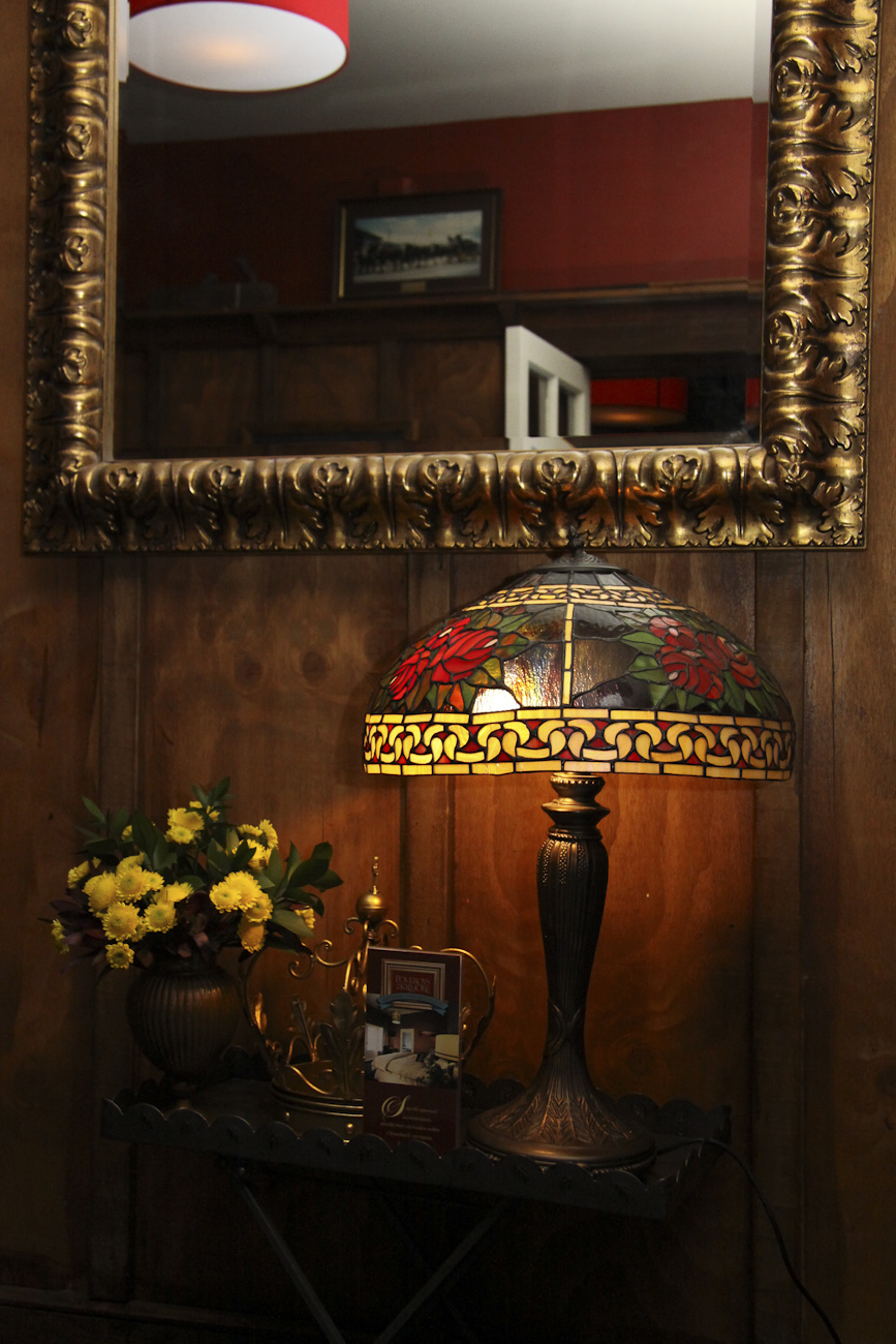 Pomeroy’s Old Brewery Inn English style pub interior details. Art Deco lamp, gilded mirror and fresh cut flower arrangement.