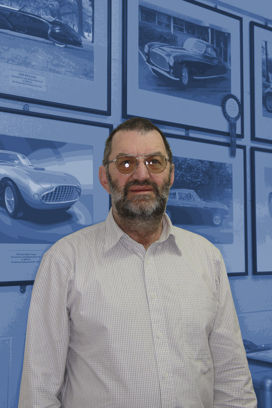 Concours award winners form the background of this informal portrait of Allan Wylie, managing director, reception area, Auto Restorations.