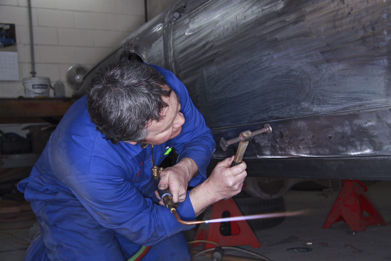 Bob Sterling precision fitting new bespoke aluminium panels on a classic Ferrari restoration in the Panel Shop at Auto Restorations.