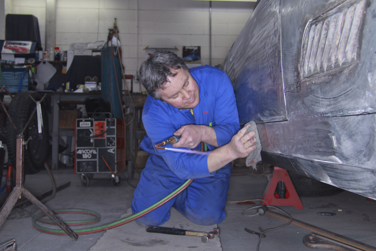 Bob Sterling precision fitting new bespoke aluminium panels on a classic Ferrari restoration in the Panel Shop at Auto Restorations.