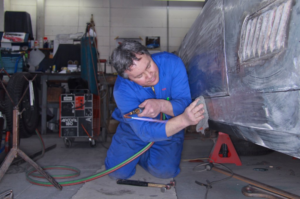 Bob Sterling precision fitting new bespoke aluminium panels on a classic Ferrari restoration in the Panel Shop at Auto Restorations.