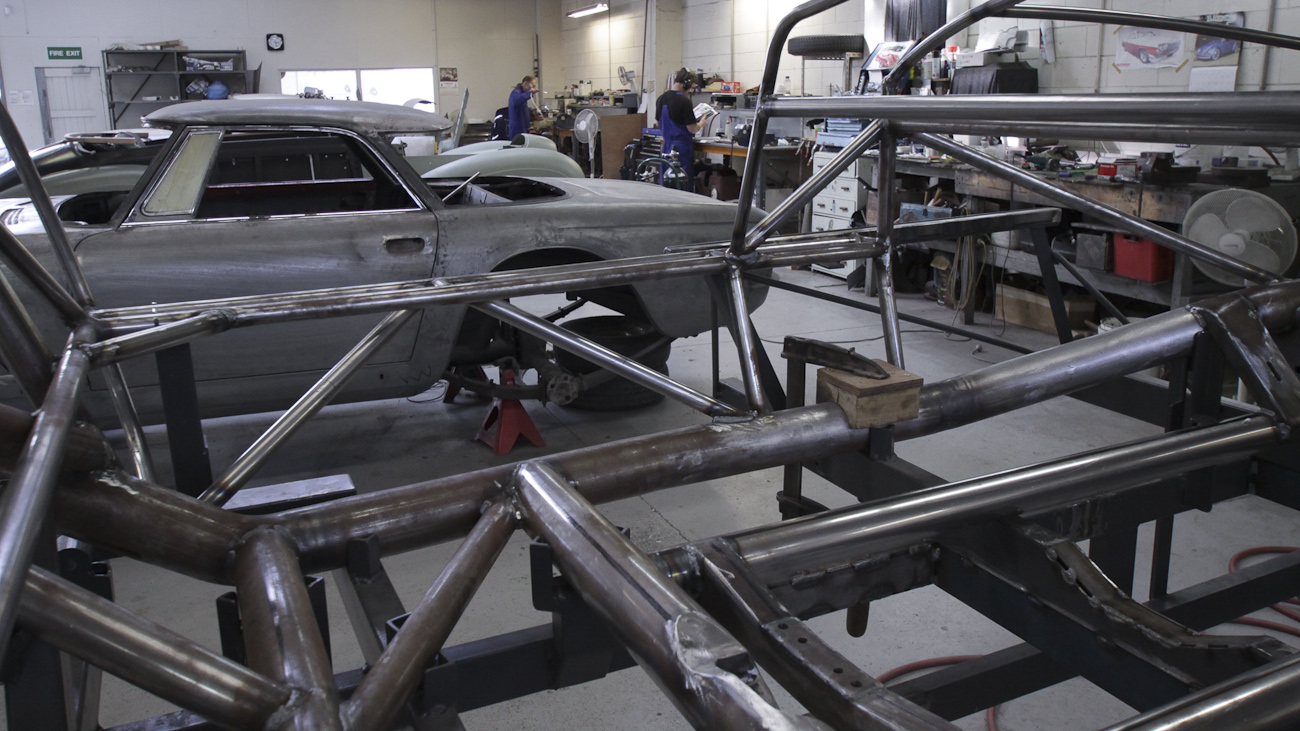 In the foreground the bespoke space frame of a 1953 Barchetta recreation “kit” car, in the Custom Coachwork Shop at Auto Restorations.
