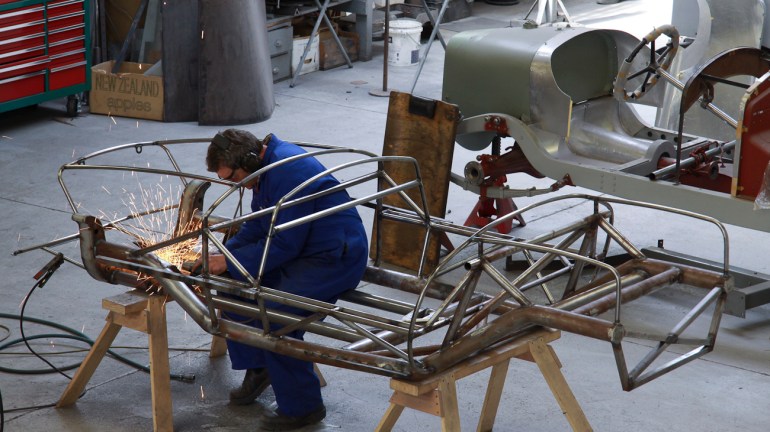 Andy Wylie hand finishing the welding on the bespoke space frame of a 1953 Barchetta recreation “kit” car, in the Custom Coachwork Shop at Auto Restorations.