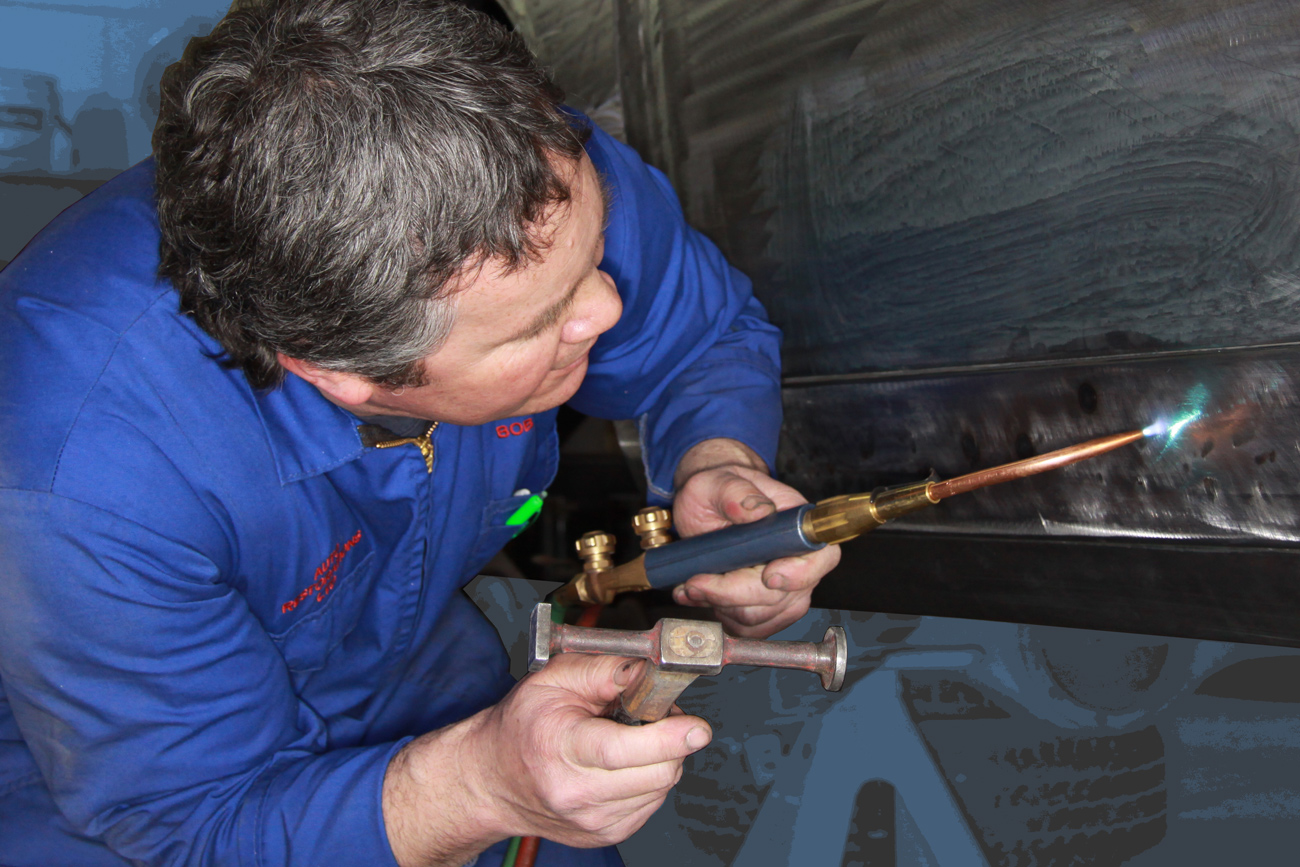 Bob Sterling precision fitting new bespoke aluminium panels on a classic Ferrari restoration in the Panel Shop at Auto Restorations.