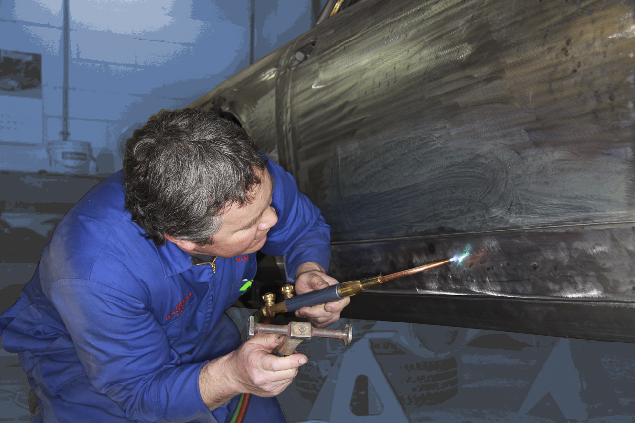 Bob Sterling precision fitting new bespoke aluminium panels on a classic Ferrari restoration in the Panel Shop at Auto Restorations.