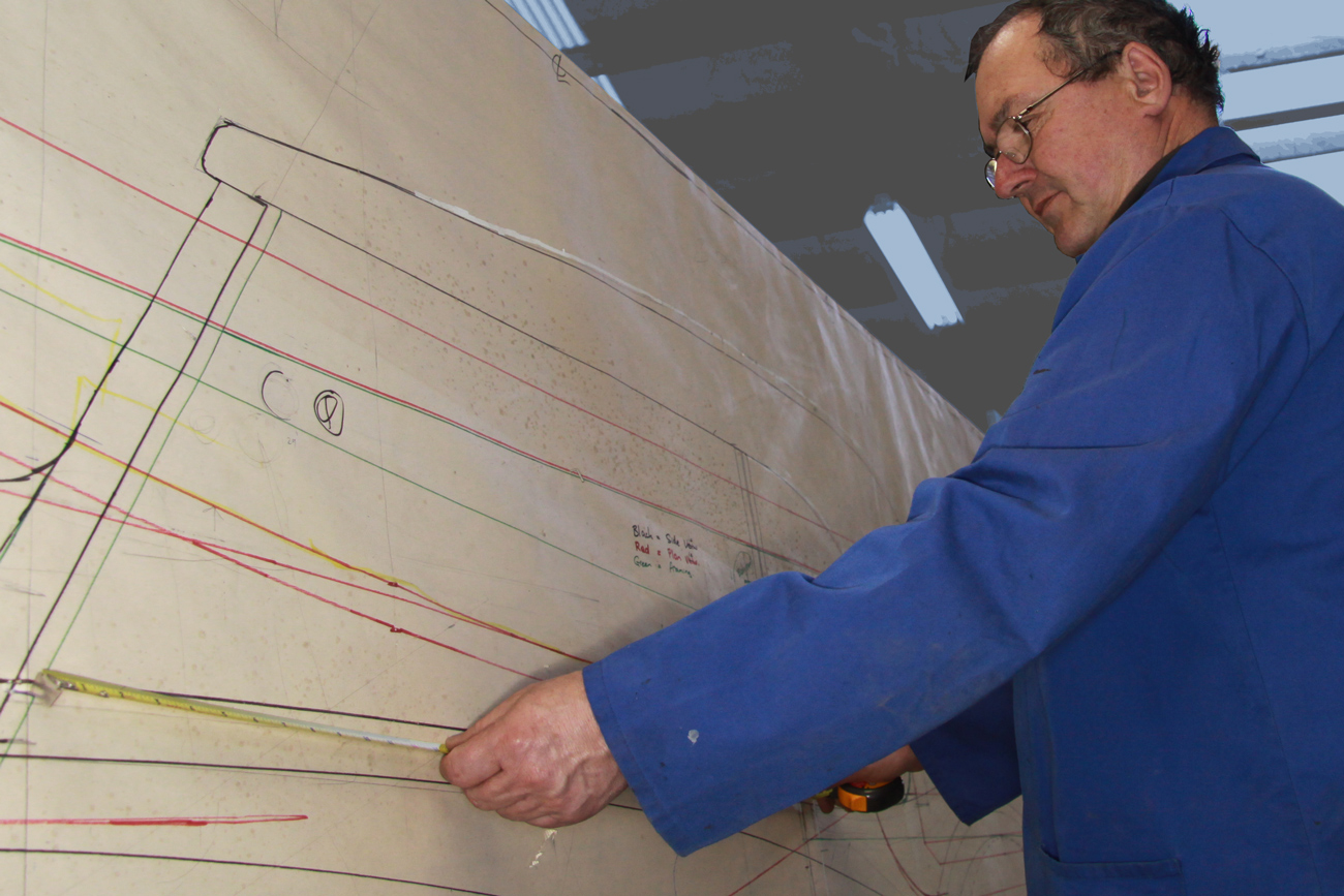 Graeme Climo dimensioning a bespoke aluminium body panel for a classic Delage restoration in the Custom Coachbuilding Shop at Auto Restorations.