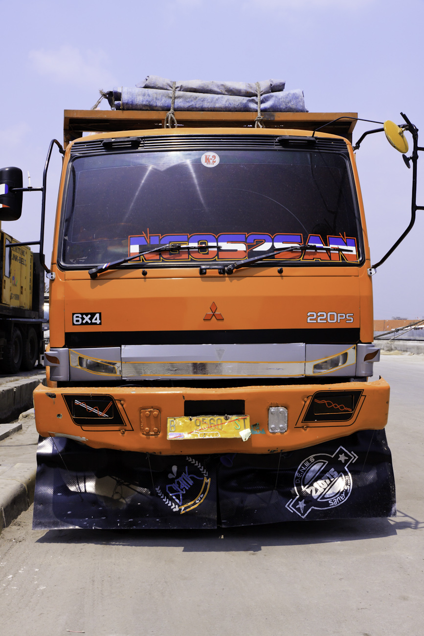 A freight truck named ‘NGOS3SAN’ lined up on the wharf at the port of Sunda Kelapa.