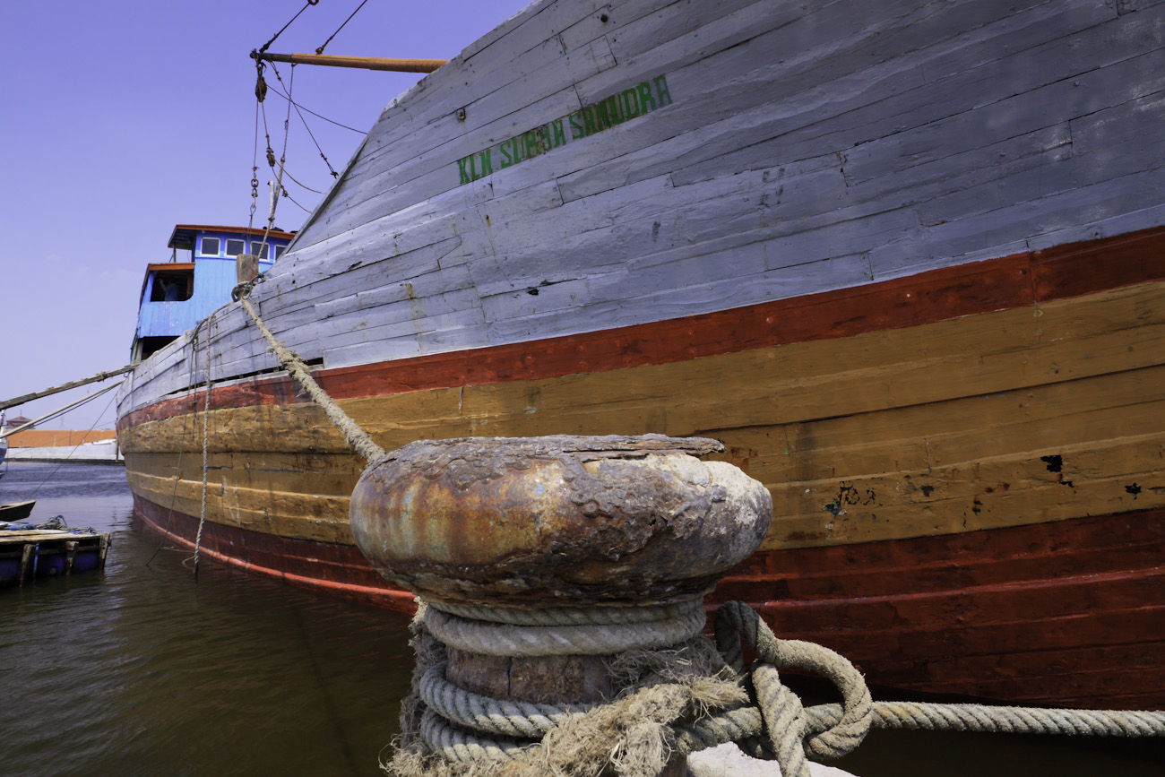 The colourful hull of a lambo or lamba type of motorised Pinisi, named KLM SURYA SANUDRA, moored at the port of Sunda Kelapa, Jakarta, Indonesia.