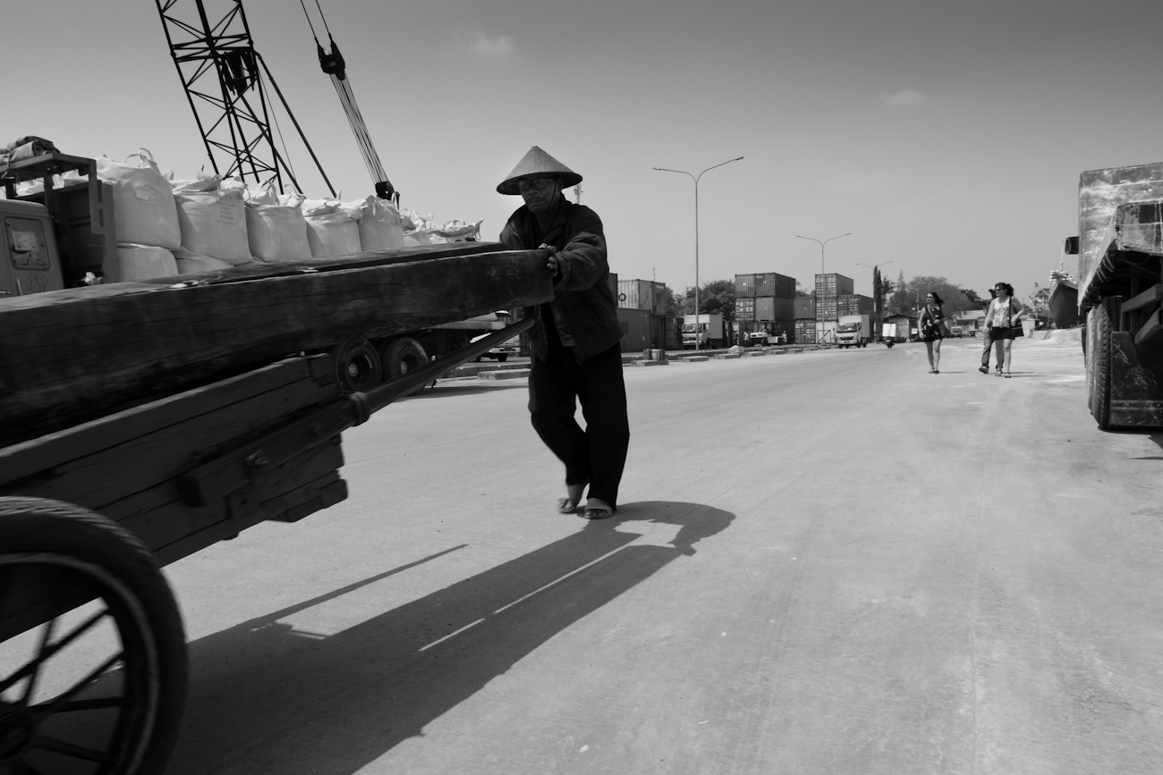 A Coolie port worker loading sawn logs on a hand pushed cart at the port of Sunda Kelapa, Jakarta, Indonesia.
