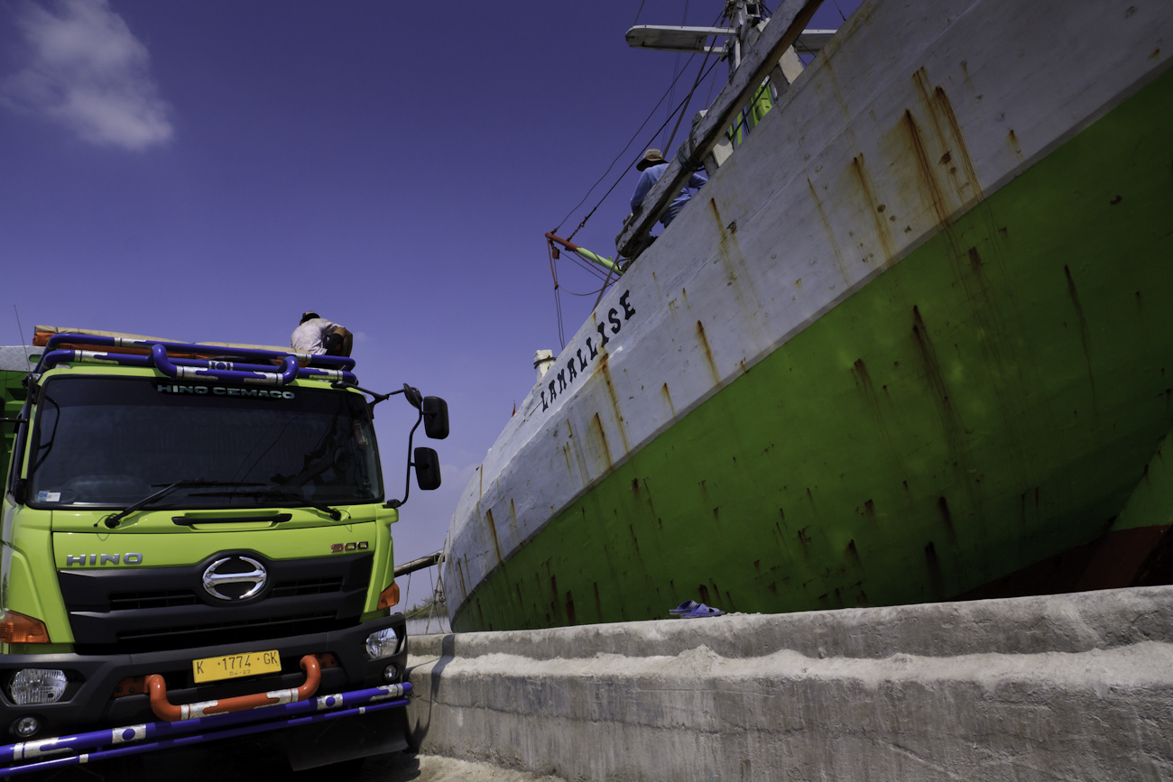 Coolie cargo loading operations on the truck alongside and aboard the motorised Pinisi named ‘Lamallise’.