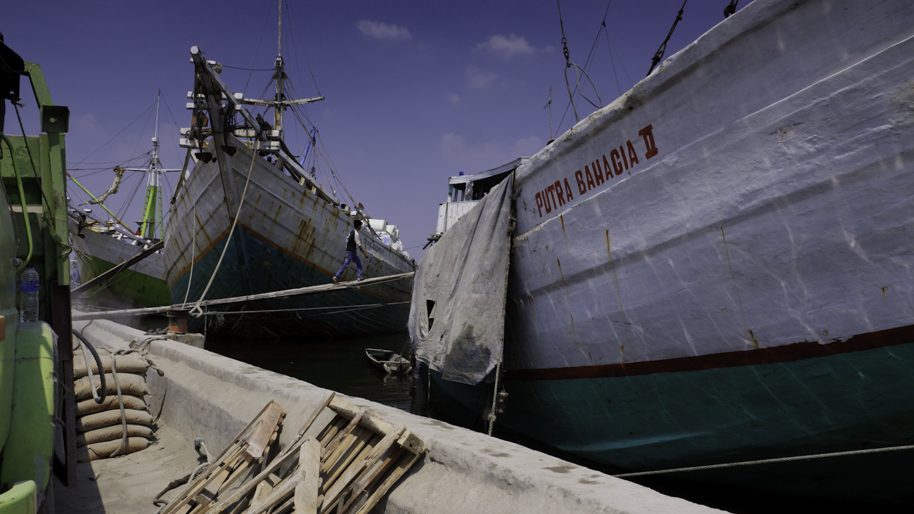 Magnificent, colourful Lamba type of motorised Pinisi line up at Sunda Kelapa, old harbour of Jakarta, Indonesia. The vessel Putra Bahagia II in the foreground.