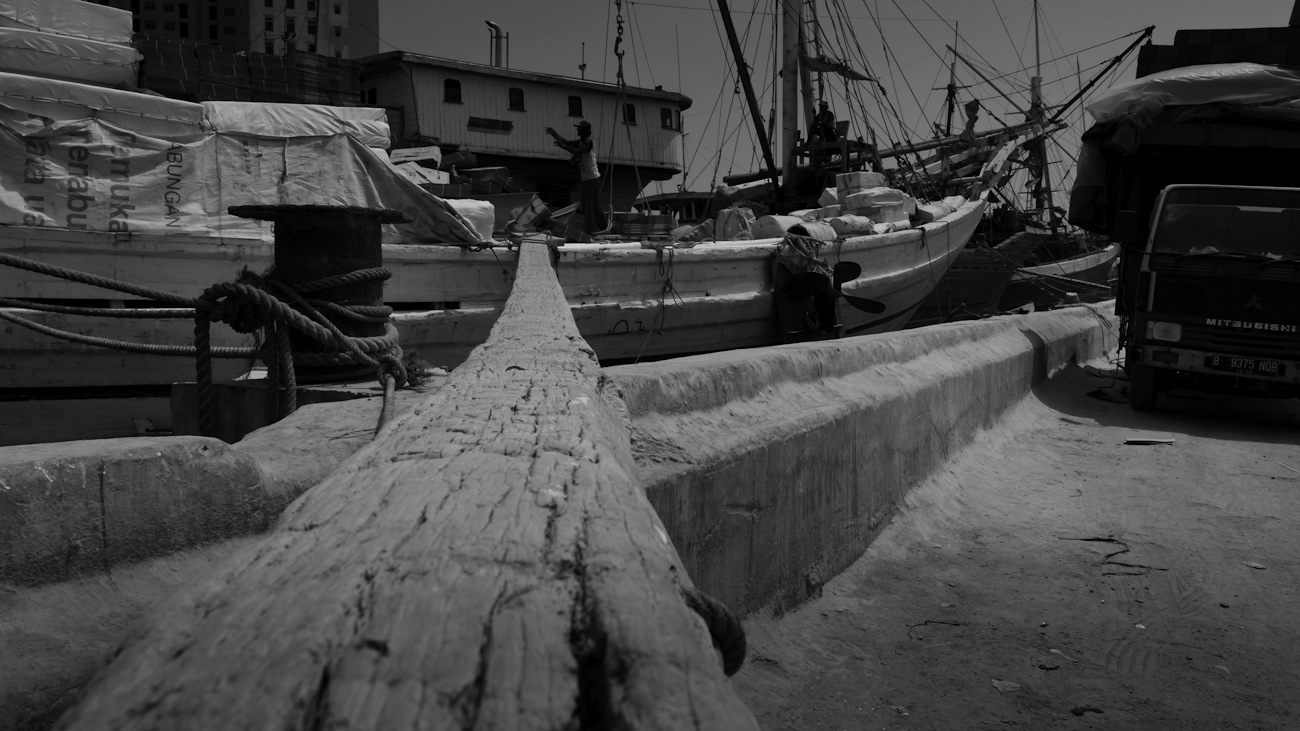Traditional old wooden gangplank leads from the wharf at Sunda Kelapa, old harbour of Jakarta, to the deck of a Lamba type of motorised Pinisi.