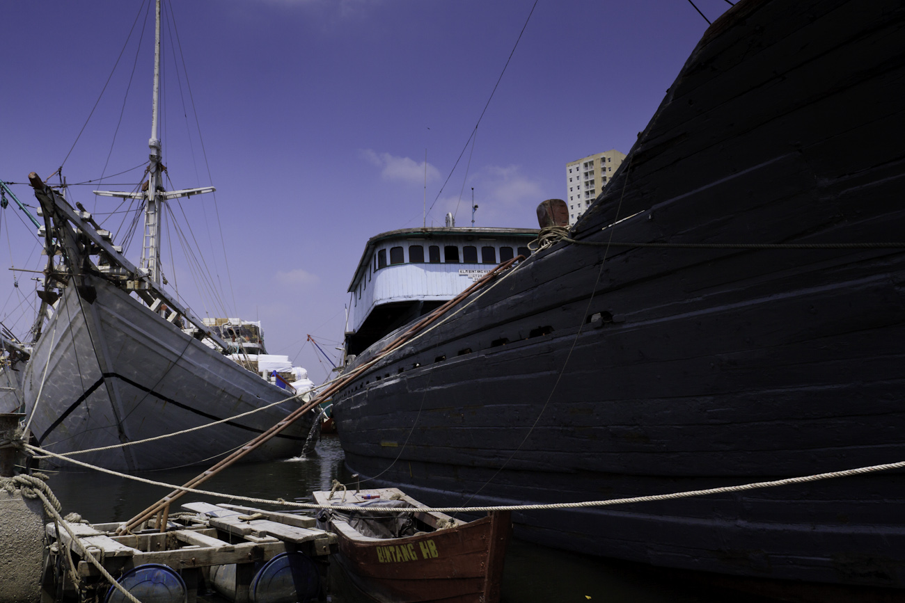Lambo or lamba type of motorised Pinisi line up at Sunda Kelapa, old harbour,Jakarta. These Pinisi are unladen and in the process of having their hulls repaired and painted above the waterline.