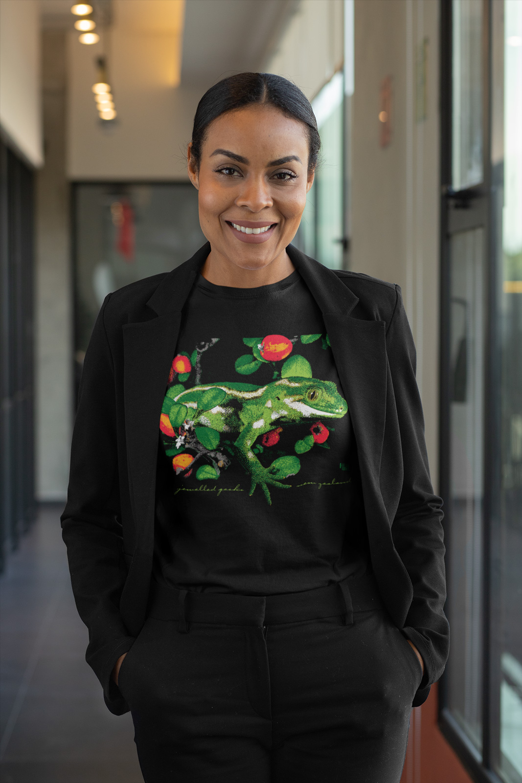 A professional woman posing in a black jewelled gecko t-shirt at the office.