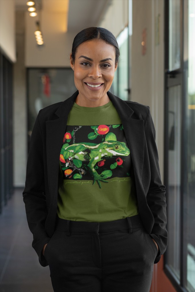 A professional woman posing in a military green jewelled gecko t-shirt at the office.