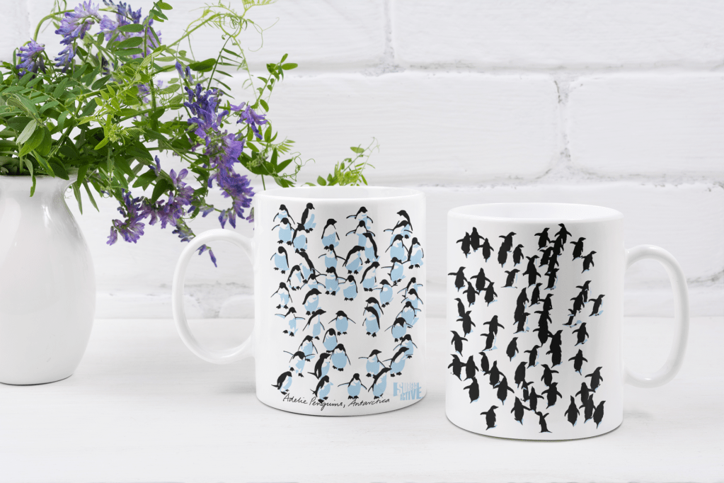 Two Adelie Penguin 11 oz mugs by a floral centrepiece