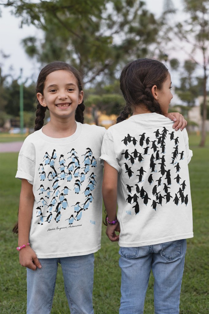 twin girls wearing Adelie penguins t-shirts showing front and back print in a park