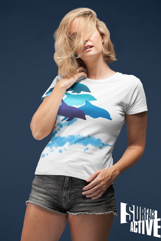 A woman wearing a dolphins leaping New Zealand all-over printed t-shirt with her hair all over her face.