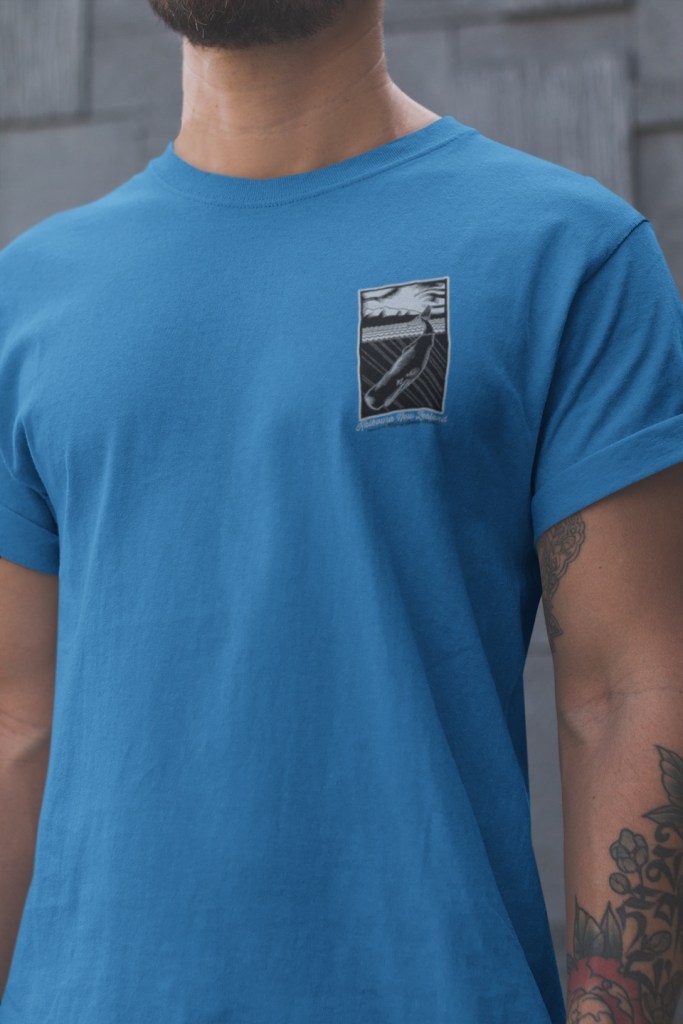 Kaikoura, New Zealand home of the mighty Sperm Whale badge print on the chest of a blue men’s t-shirt.