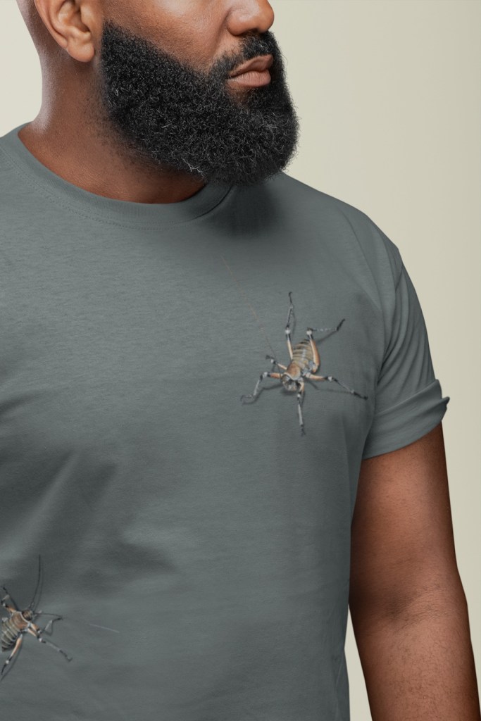 Close-up of a man with a thick beard wearing a Surface Active all-over printed weta New Zealand t-shirt.