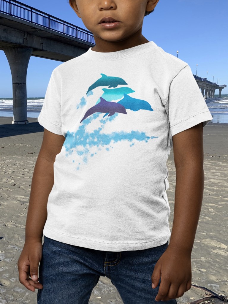 Portrait of a little kid wearing a Surface Active dolphin t-shirt at New Brighton beach, beside the pier.