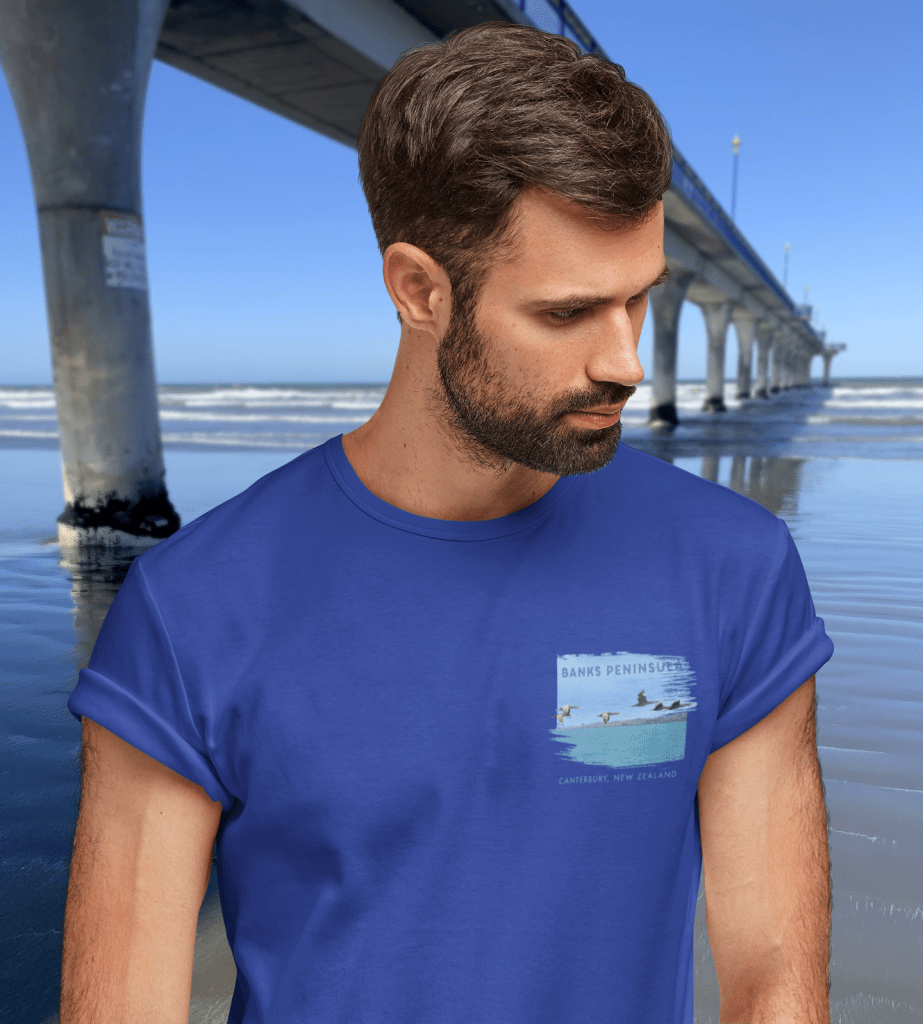 Close-up photo of the badge print on the chest of a deep royal blue Surface Active spotted shags t-shirt taken beside New Brighton pier.