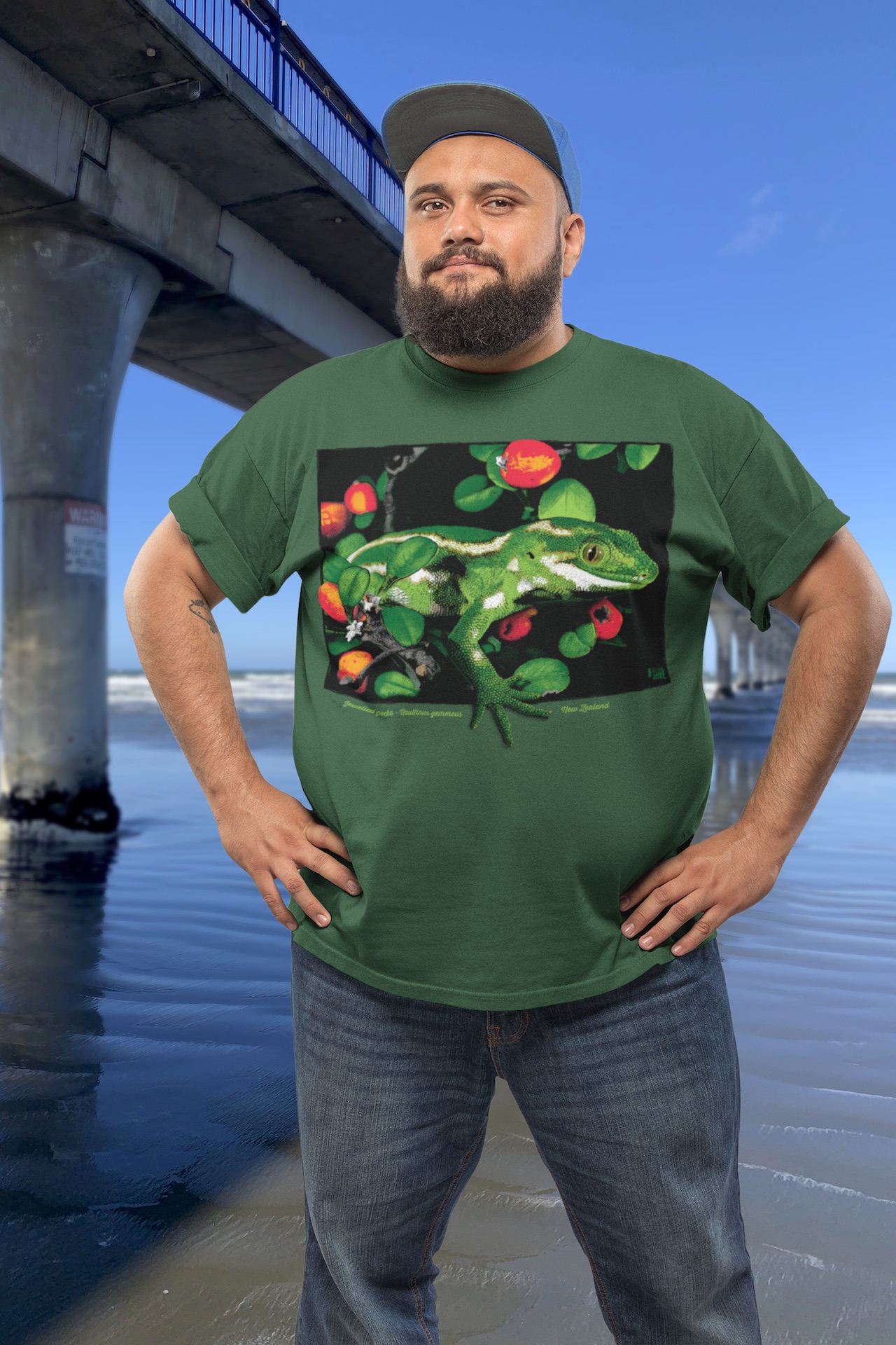 Man wearing a jewelled gecko t-shirt standing beside New Brighton Pier.