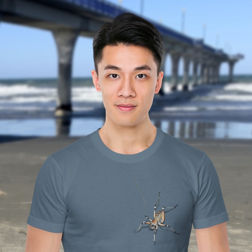 A denim blue Surface Active t-shirt with two colourful pixel painted weta on the front, one on the sleeve and one on the back.