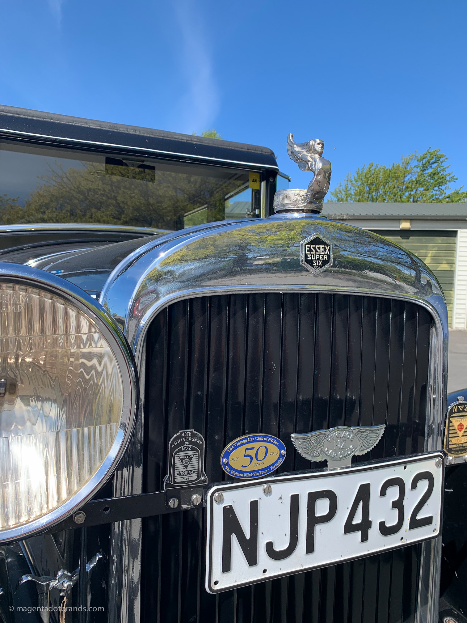 Abstract close-up view of the right hand side headlight and chrome grille of a restored 1928 Essex Super Six