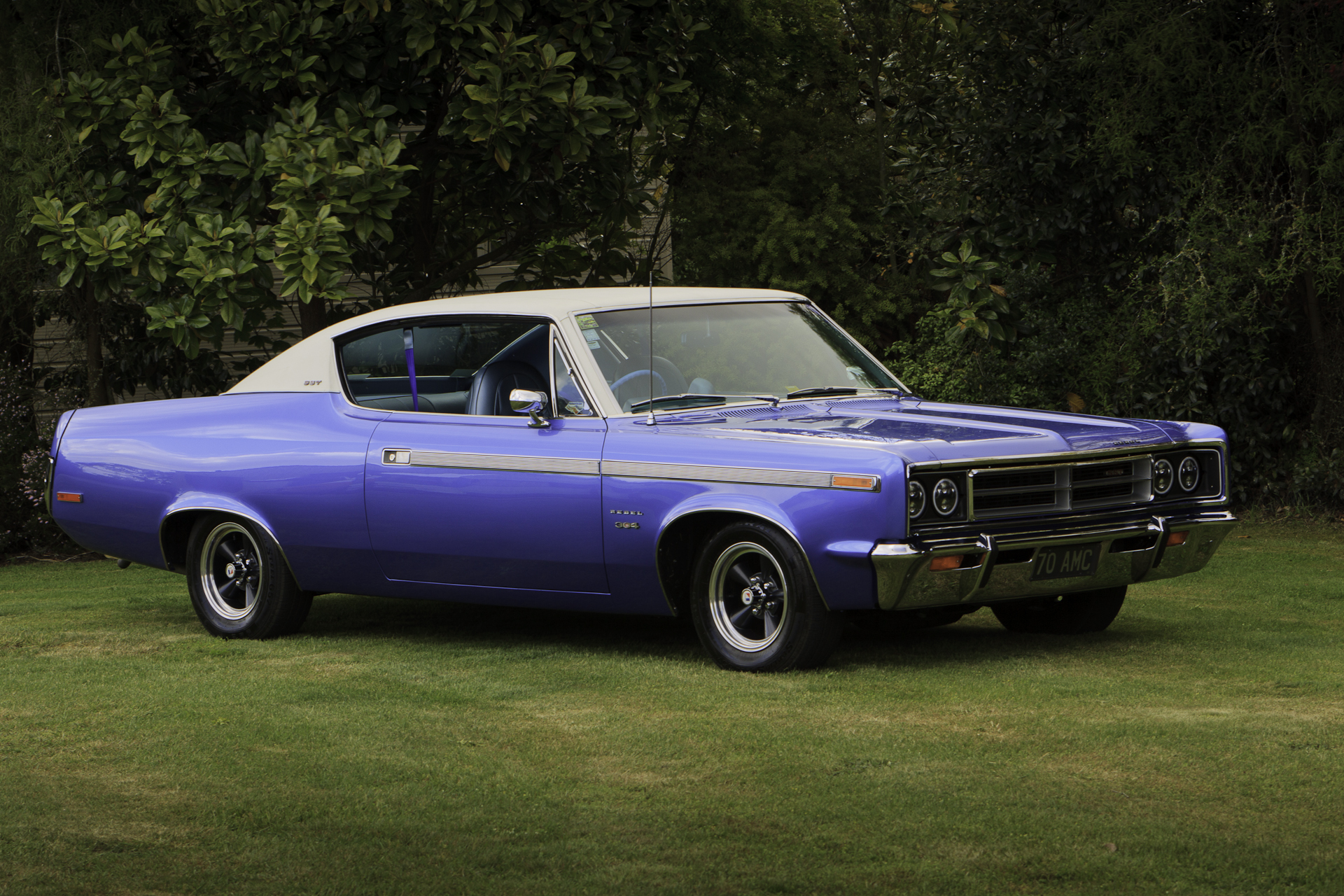 Royal blue 1970 Rambler Rebel SST viewed from the driver's side with an angle towards the front, highlighting the hood, grille, and bumper.