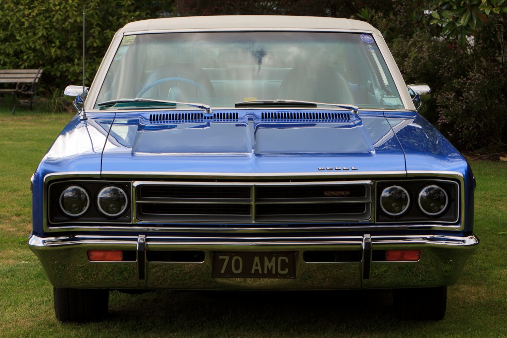 Front view of a royal blue 1970 Rambler Rebel SST, showcasing its iconic grille, hood, and bumper from a mid-windshield perspective.