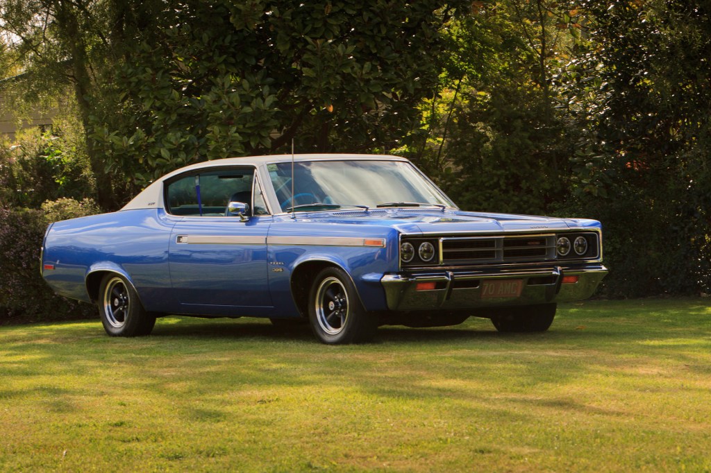 Front three-quarter view of a restored 1970 Rambler Rebel SST in royal blue, taken from a low angle emphasising the car's headlights and classic muscle car design.