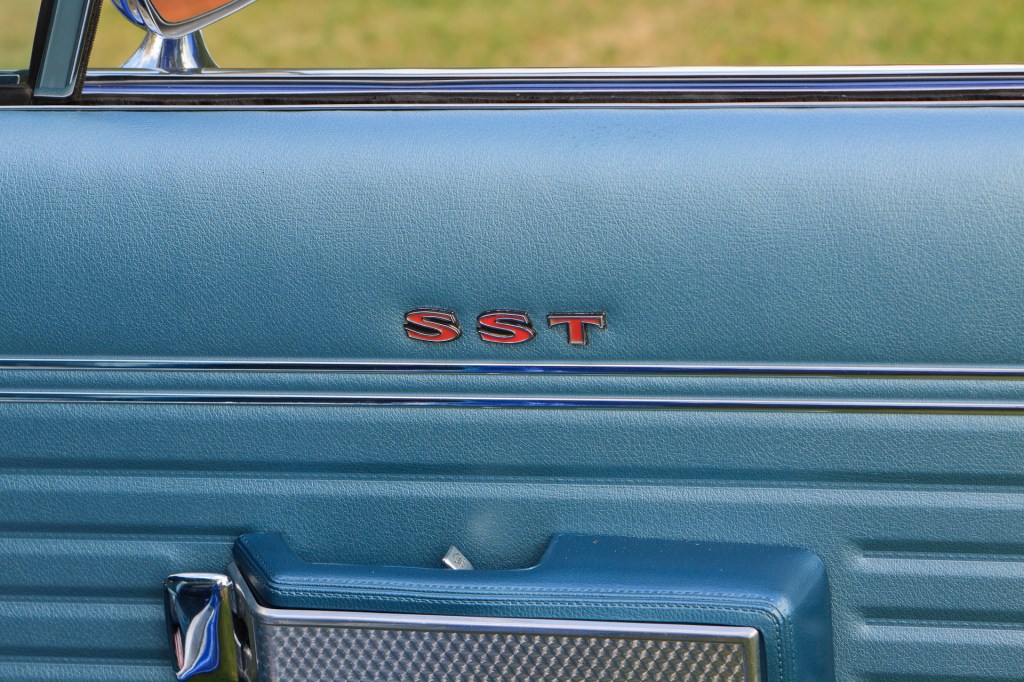 Close-up of 1970 Rambler Rebel SST's driver door interior with royal blue metallic vinyl, chrome bright work, and Rebel SST badging.