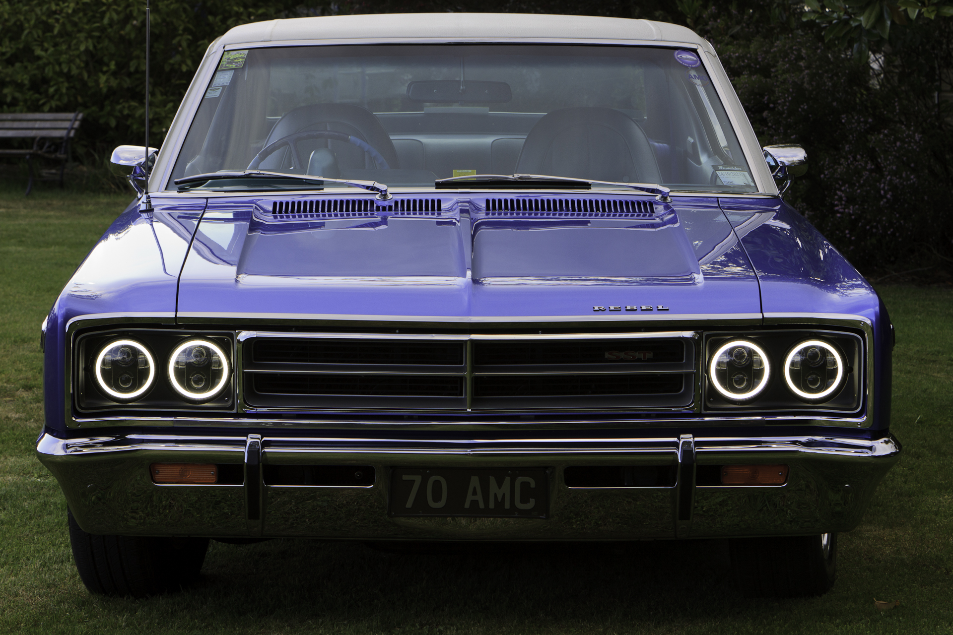 Restored 1970 Rambler Rebel SST in royal blue, showcasing its classic design and powerful 304 V8 engine, parked in a scenic outdoor setting.