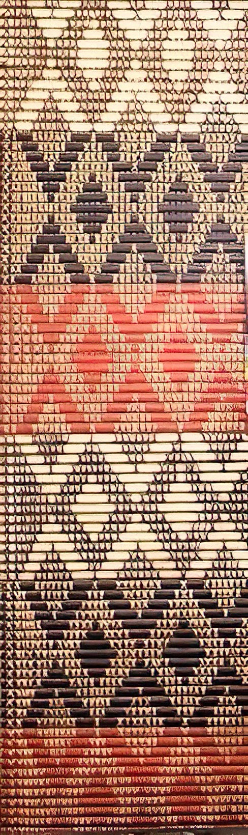 A Maori tukutuku panel with a pattern resembling the Harlequin Gecko's skin, featuring geometric diamond shapes.