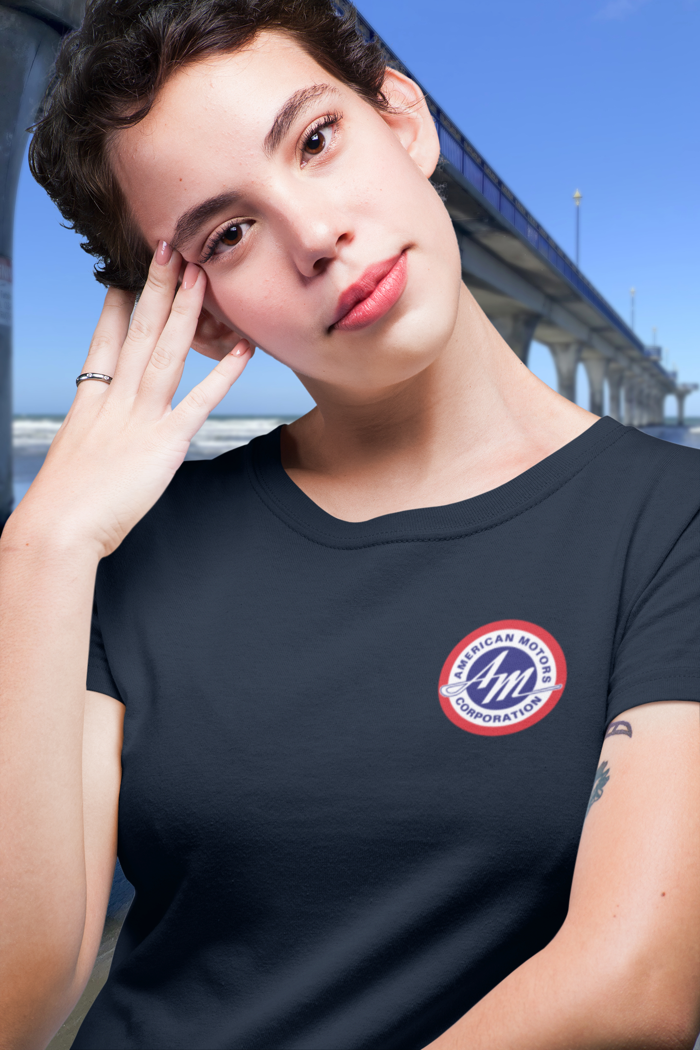 Woman in navy blue t-shirt with 1967 AMC Marlin logo badge on chest.