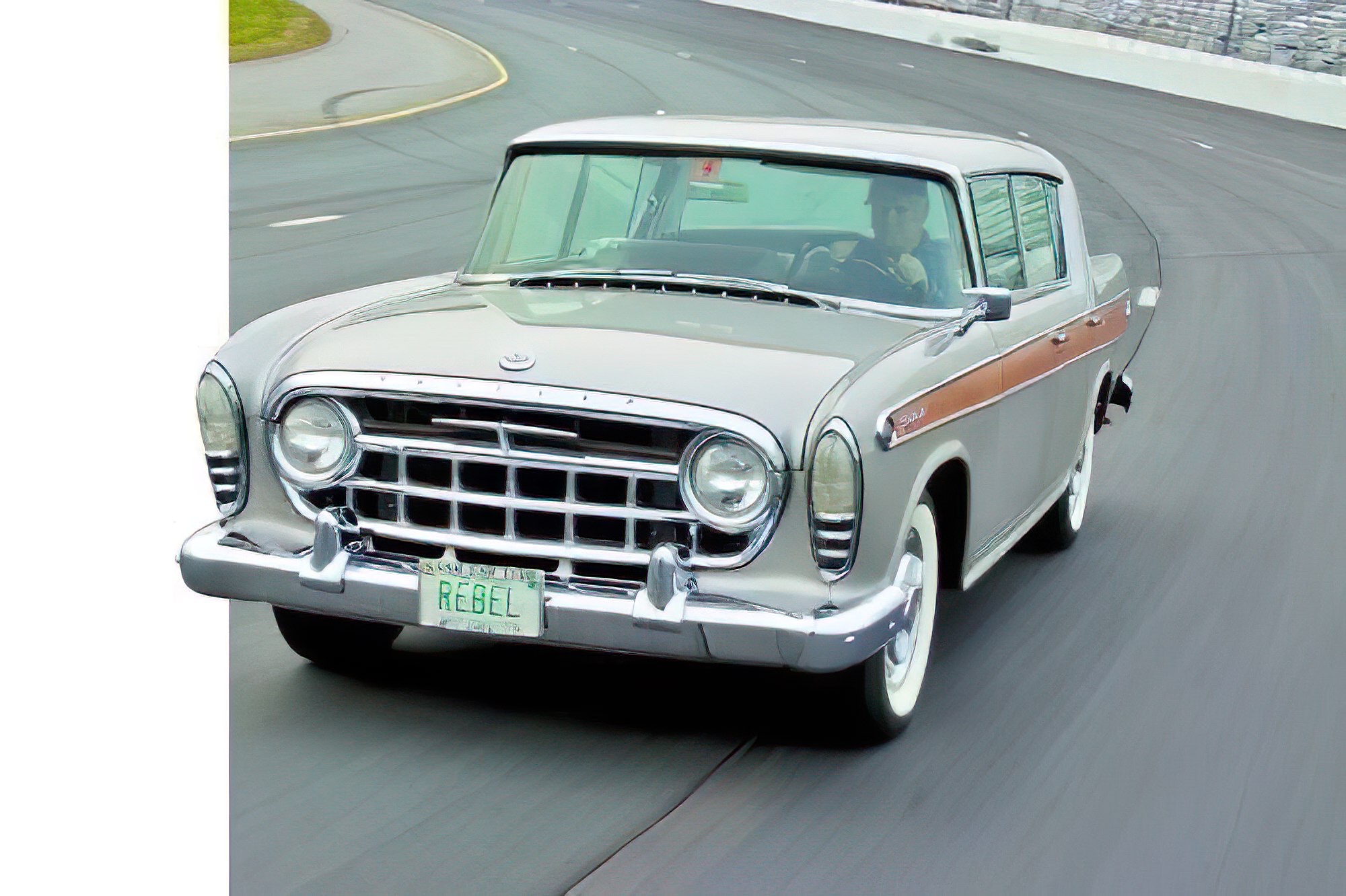 1957 Rambler Rebel sedan on a test-driving track, showcasing its silver finish and classic design.