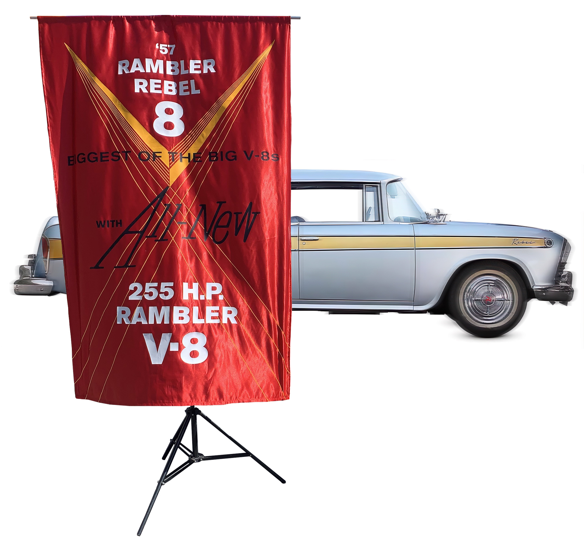Photocomposite of a 1957 Rambler Rebel sedan in motion as a blurred silver streak backdrop, with a crisp red silk banner in the foreground featuring heat-pressed vinyl graphics.