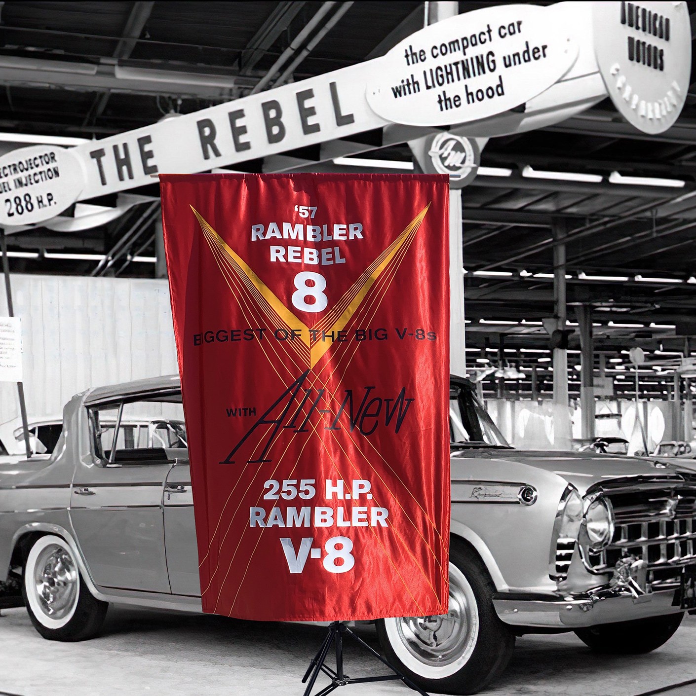 Photocomposite of a 1957 Nash Rambler silk banner in lustrous red with a black-and-white 1957 Rambler Rebel sedan auto show image.