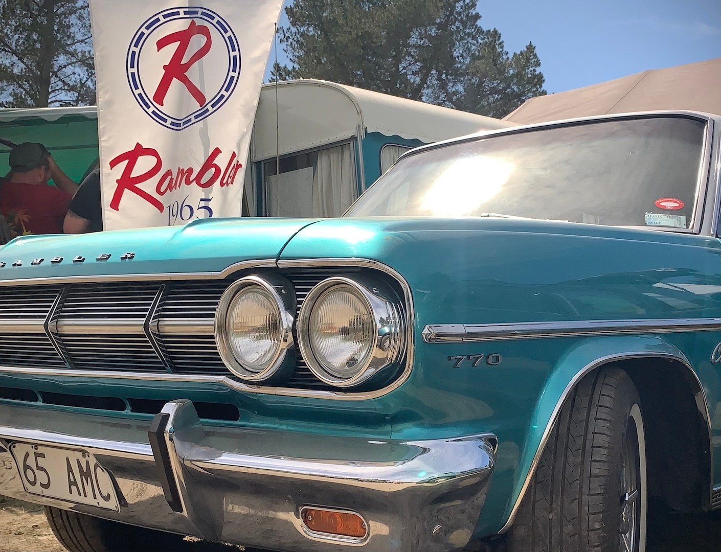 Restored 1965 Rambler Classic 770 Countryman station wagon with a red, white, and blue authentic, re-created, American Motors dealership banner, at the 2024 McLeans Island swap meet.